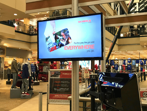 A large digital signage display in a retail clothing store of a mall