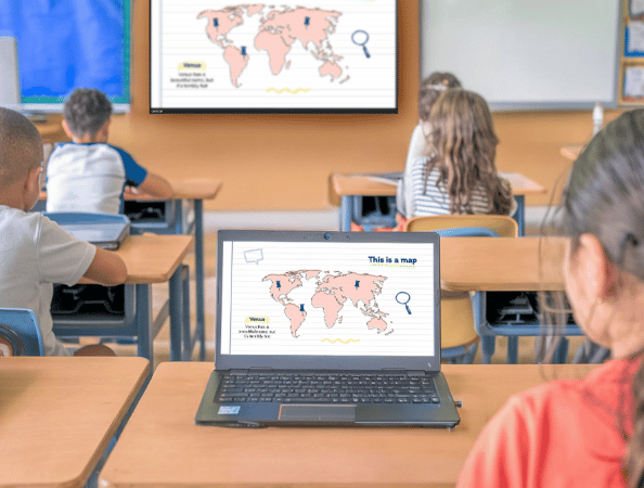 Students in a classroom viewing a shared screen on her laptop