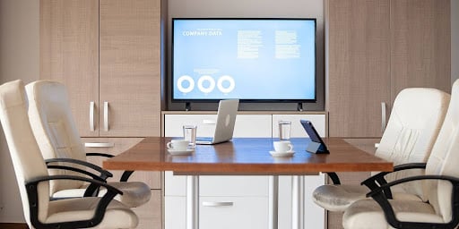 A professional conference room displaying dynamic digital signage content, showcasing the versatility and effectiveness of modern communication methods.