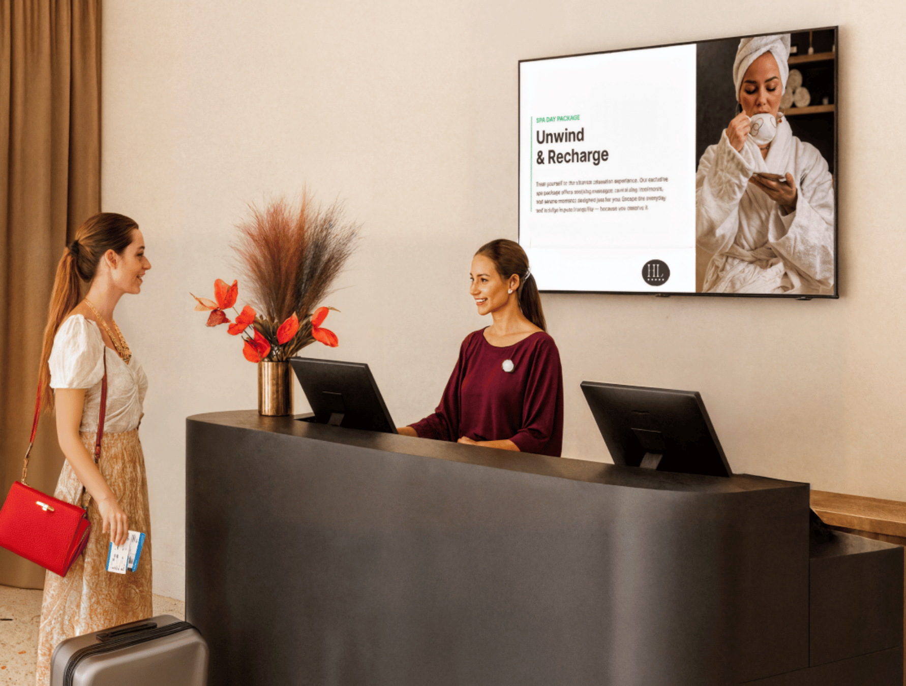 A female customer speaking with the receptionist of a spa facing a large display signage on the wall