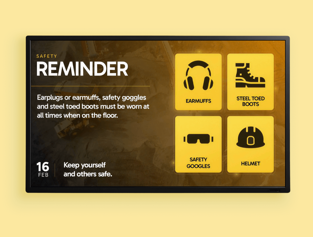 A digital signage display showing a safety reminder with icons of earmuffs, steel toe boots, safety goggles and hard hat