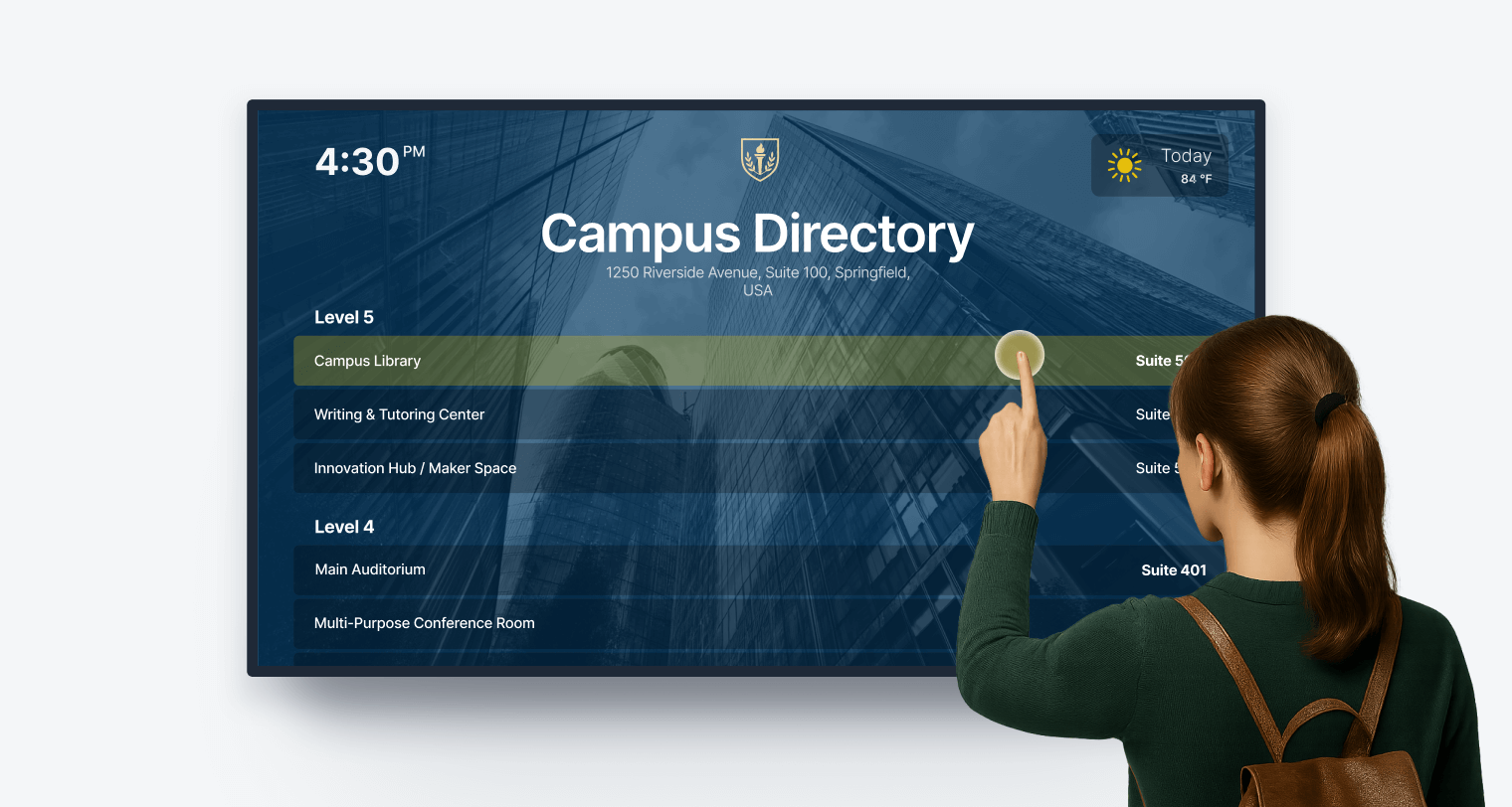 A young woman touching an interactive display showing a campus directory