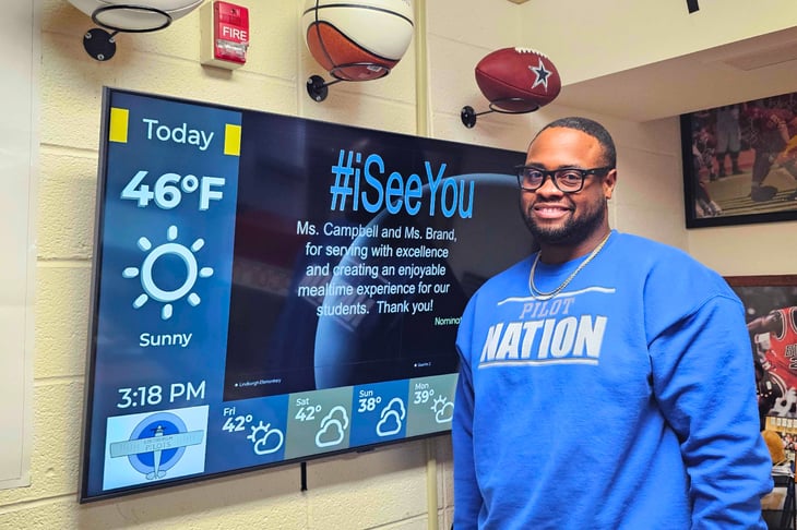 Dr. Wiley standing in front of a digital display for staff recognition