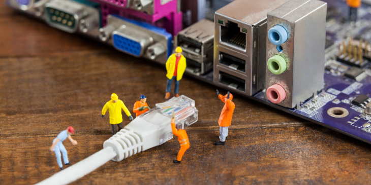 Miniature workers with an ethernet cable.