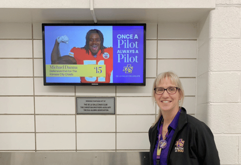 Sheryl Anderson in front of digital signage