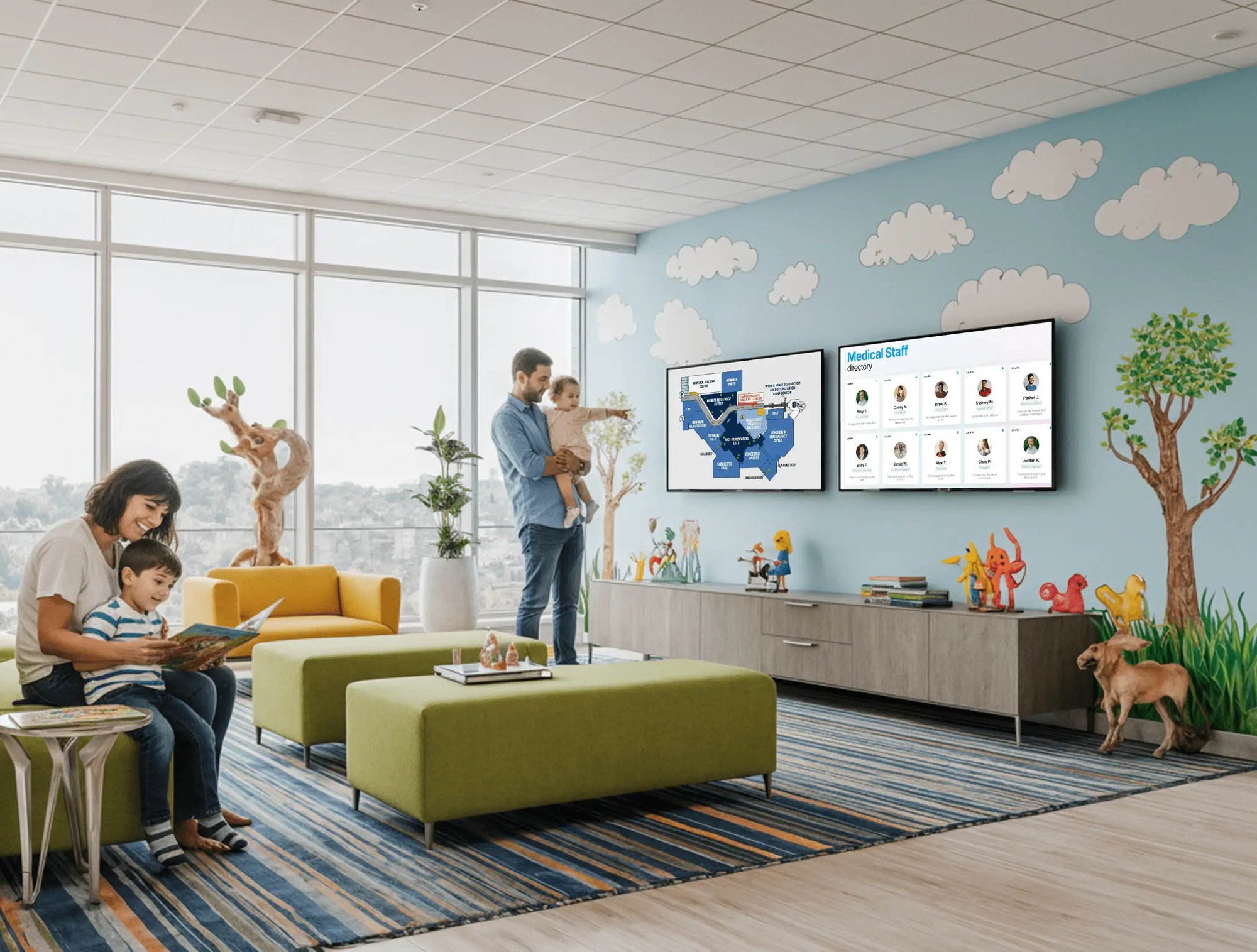 Male and female parents with their children in the waiting room of a hospital where digital displays are on the walls