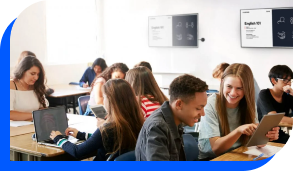 A classroom full of students with digital displays on the wall showing educational content.