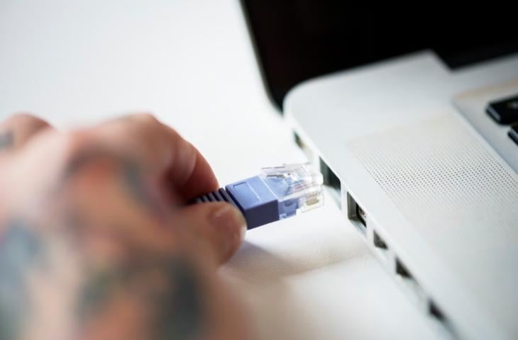 Attaching an ethernet cable to a laptop.