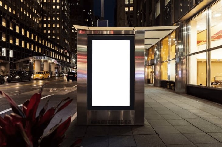 Digital signage at a bus stop at night. 