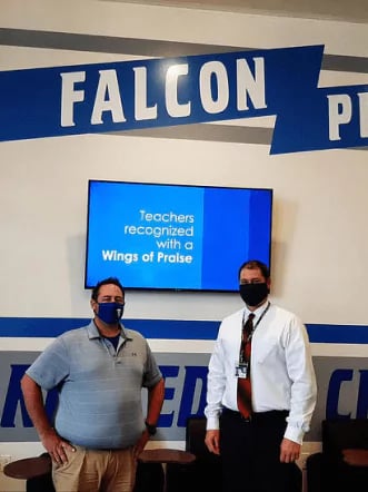 Scott and Jason in front of a digital sign