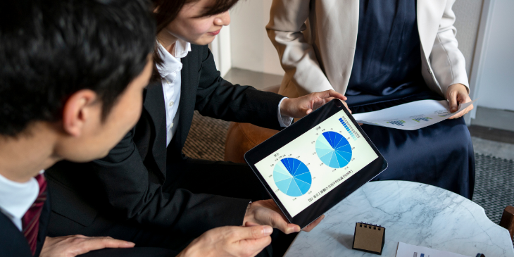Three coworkers working on a digital dashboard.