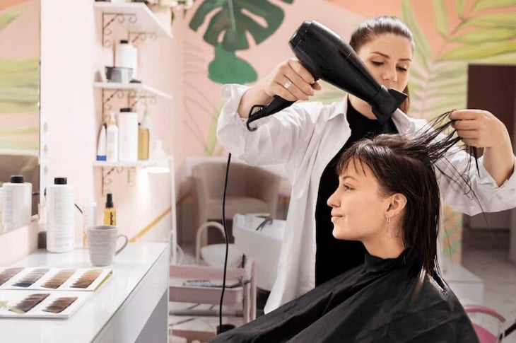 Customer getting her hair blow-dried at a salon. 