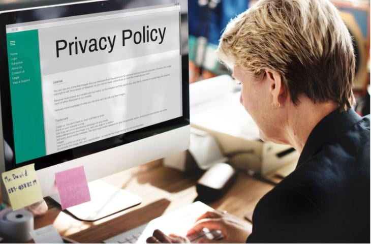 A woman reading a company’s data privacy policy on her computer.