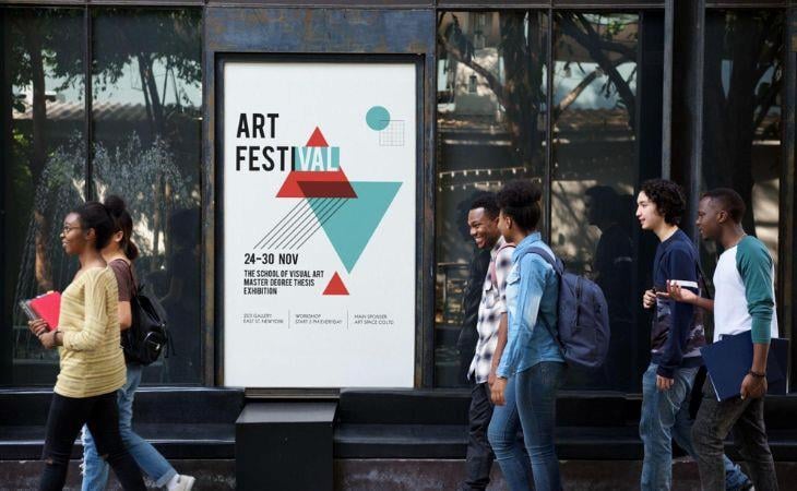 A group of students walking pass a digital signage screen.