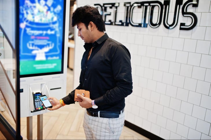 Man making a payment on digital signage.