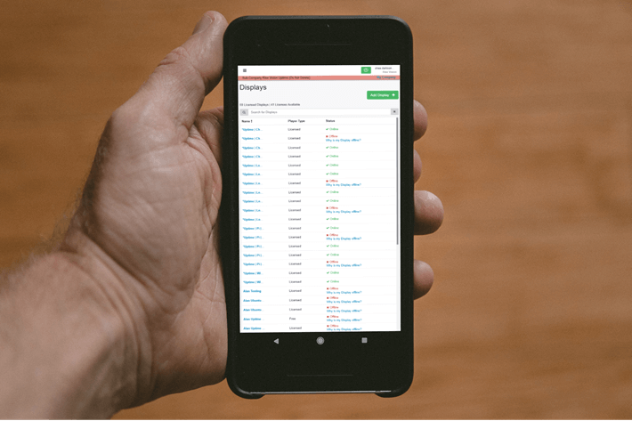 A phone showing a digital signage software network dashboard