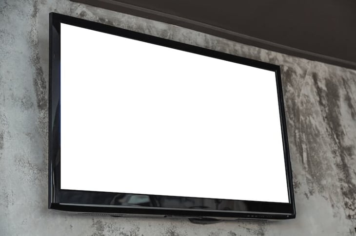 Large TV screen mounted on a wall. 
