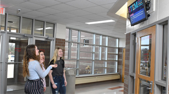 students in front of digital signage