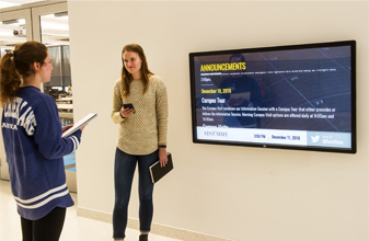 two students having a discussion in school hallway