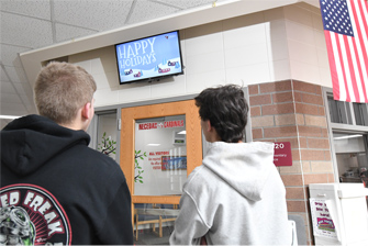 two students looking up at hallway signage