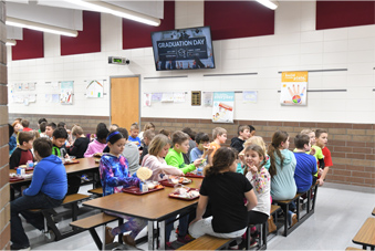packed school cafeteria - congratulations signage being displayed