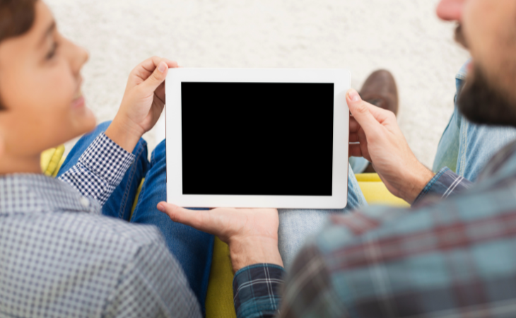 father and son looking at tablet