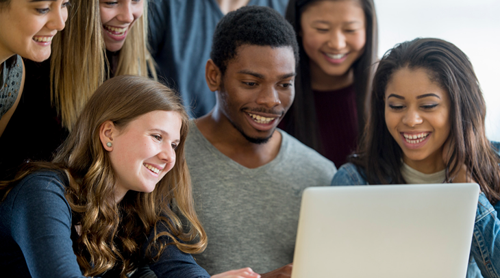 A group of students watching a video from a laptop