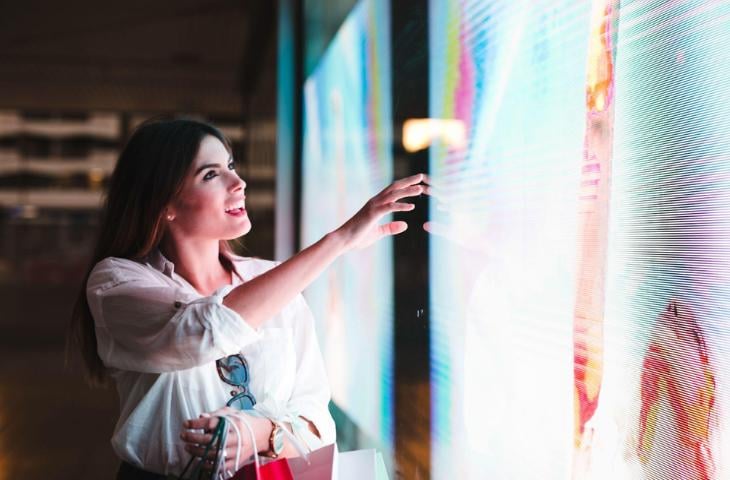 A woman looking at a digital display showing high-res images.