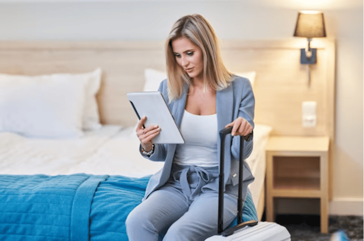 Woman using a tablet in her hotel room.