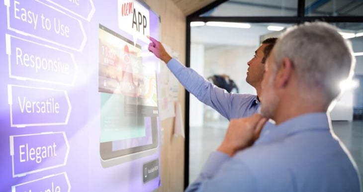 Two men interacting with a digital sign. 