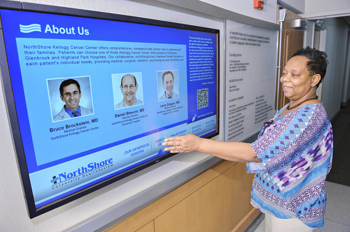 A digital sign showing someone interacting with an interactive digital sign