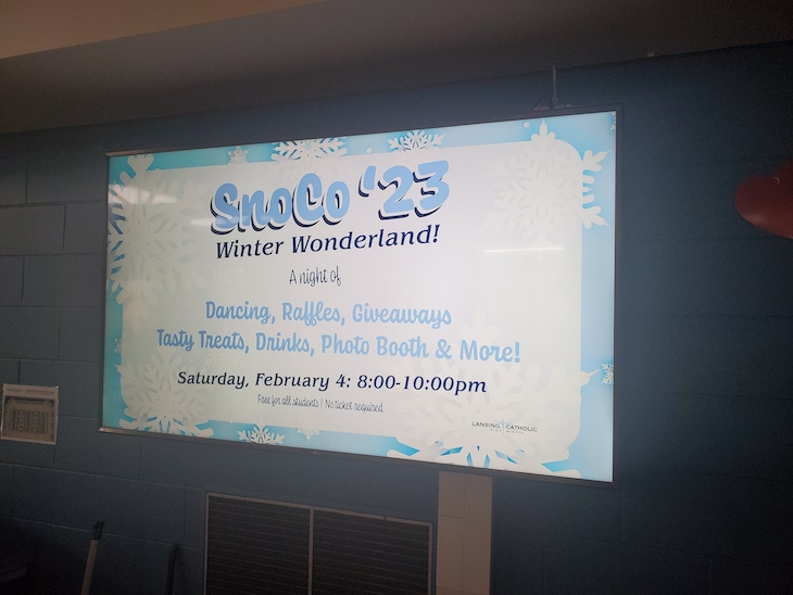 Digital signage at Lansing Catholic High School showing a SnoCo '23 promotion