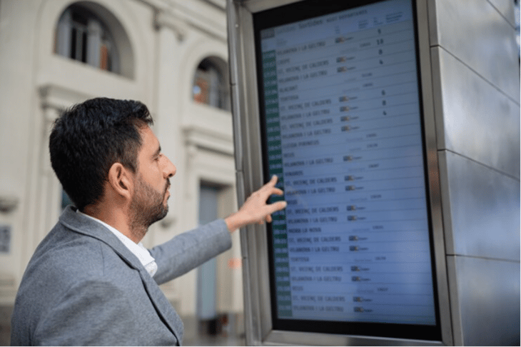 Man looking at data on a digital signage screen.