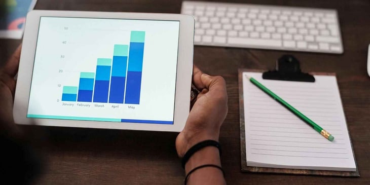 A man holding a tablet with the chart.