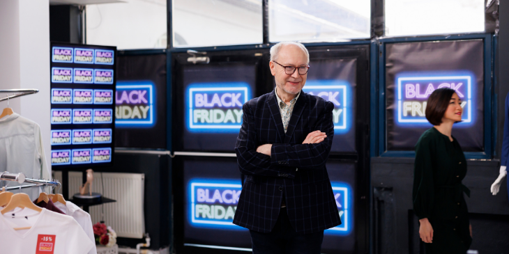 Man in a Black Friday sale with digital signage.