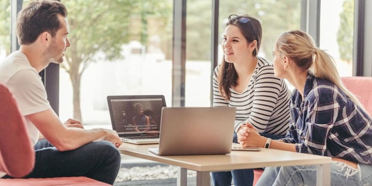 Two women and one man engage in discussion, representing the changing dynamics in the workplace influenced by millennial preferences and values.