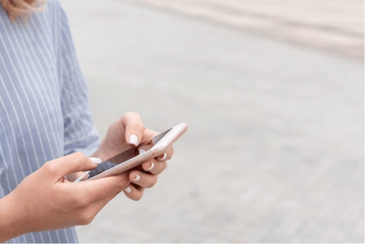 A woman reading a text on her mobile phone.