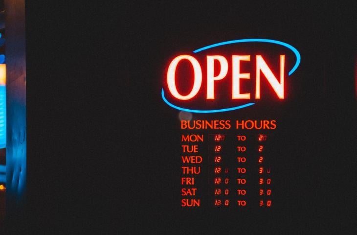 Digital signage displaying the open sign and business hours.