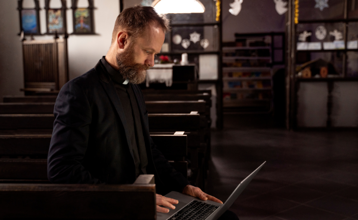 priest working on laptop