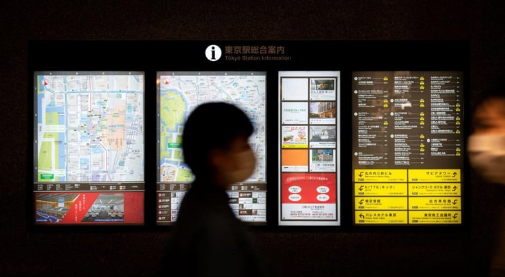 Man walking by digital signage.