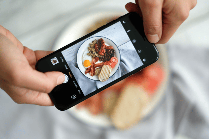 A person taking a photo of a meal on an iPhone.