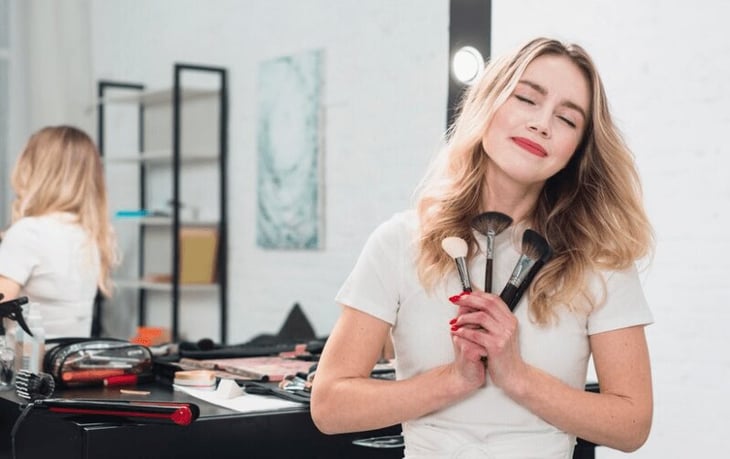 Salon makeup artist holding her brushes. 