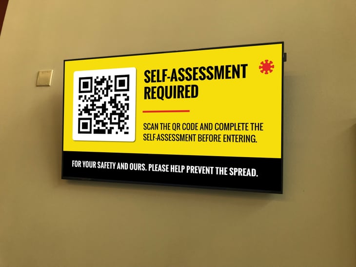 Digital signage explaining that a self-assessment quiz is required before entering.