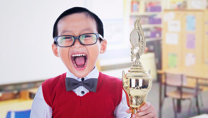 A happy student holding a trophy