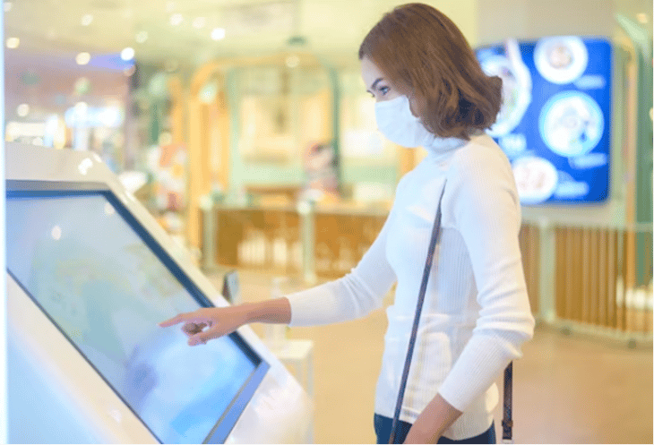 A woman interacting with a digital sign.
