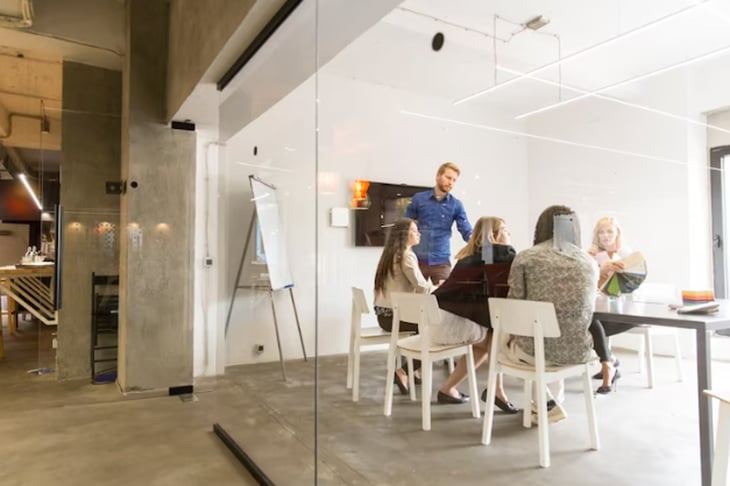 Employees having a meeting inside a boardroom.