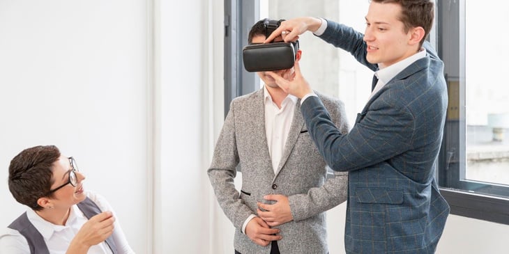 A man wearing a virtual reality headset engages with clients, showcasing how VR technology creates competitive and immersive experiences for clients.