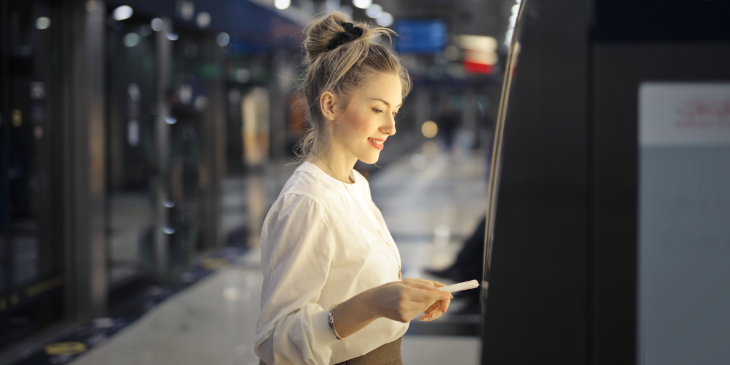 Woman using a digital signage ATM.