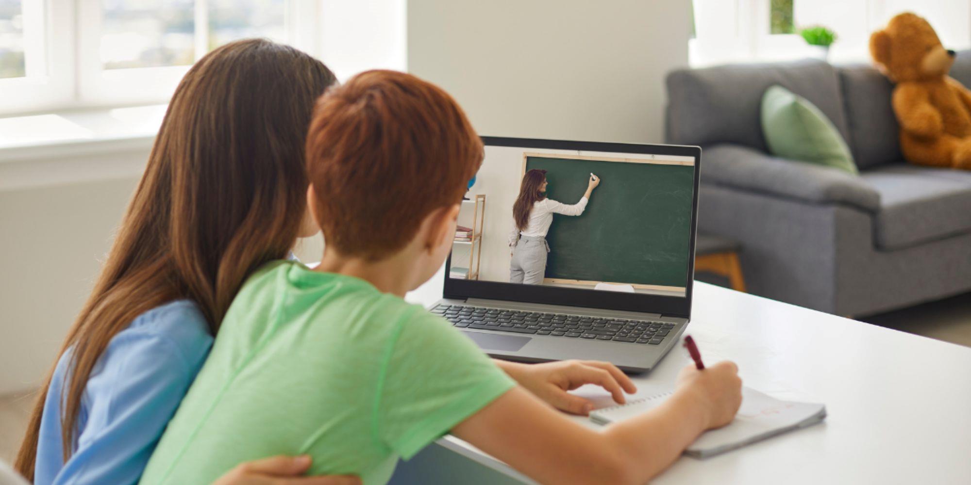 А kid and its mother are watching a digital screen for effective communication with a teacher.