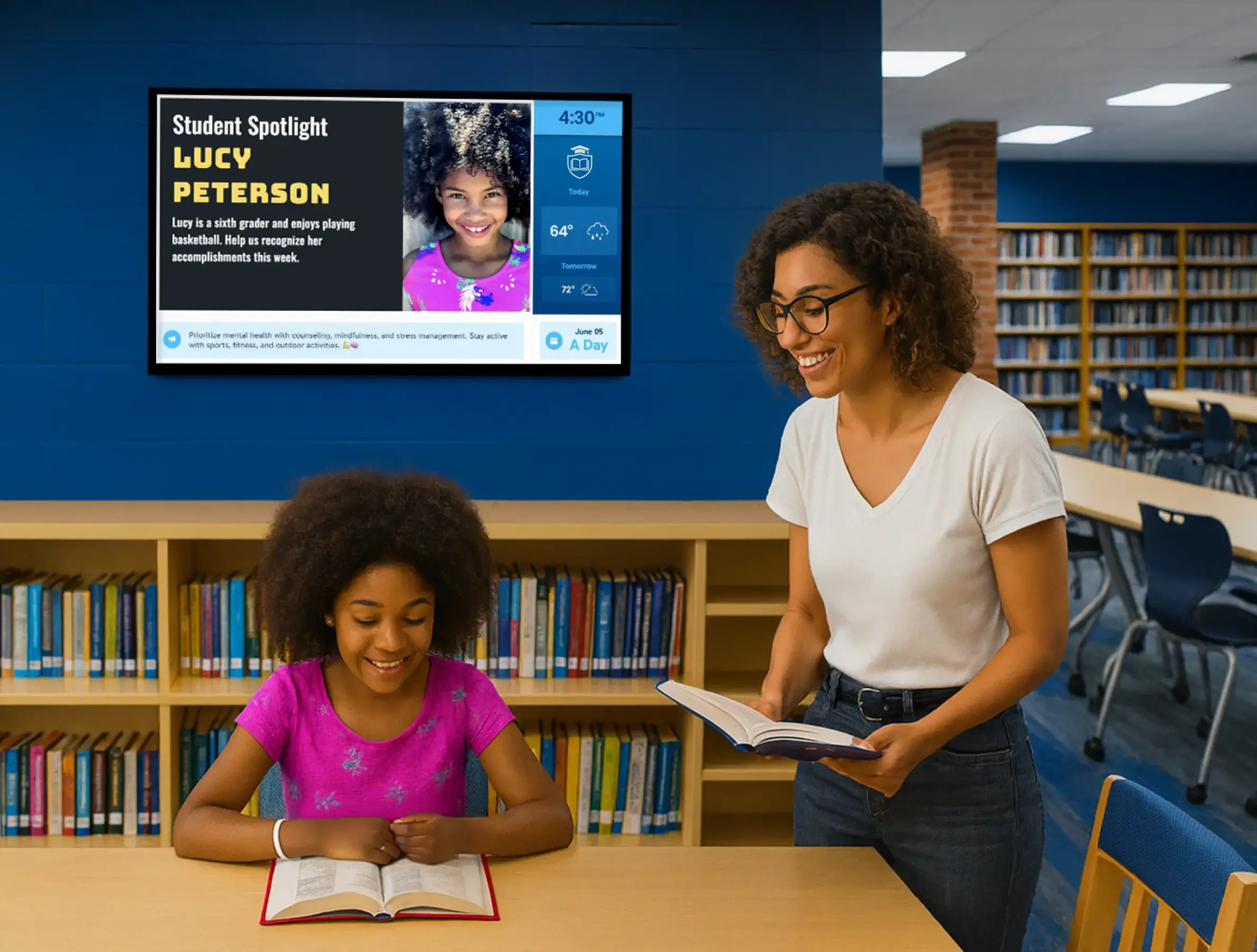 Library interior with a child and teacher showing digital display in the background